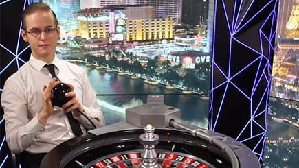 Ein Croupier betätigt den Mechanismus, mit dem beim Double Ball Roulette die beiden Spielkugeln in den Kessel katapultiert werden.