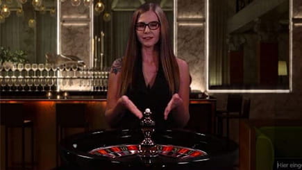 Ein Croupier präsentiert das Deutsche Live Roulette an einem Spieltisch, der von NetEnt bereitgestellt wird.