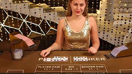 Ein Live Dealer an einem Grand Baccarat Spieltisch bereitgestellt von Playtech.
