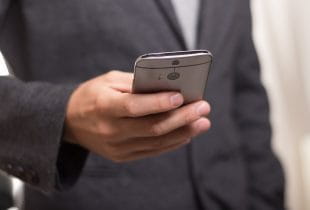 Ein Mann hält ein Smartphone in der Hand.