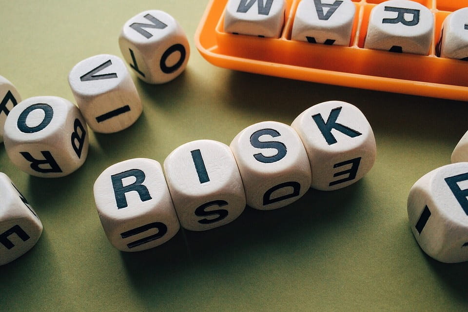 Würfel mit Buchstaben in geordneter Reihenfolge erheben das Wort „RISK“