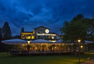 Das beleuchtete Grand Casino Baden bei Dämmerung.