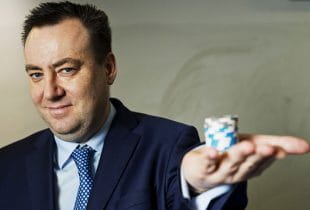 Kenny Alexander, CEO von GVC Holdings, mit einem Stapel Pokerchips in der gehobenen Handfläche