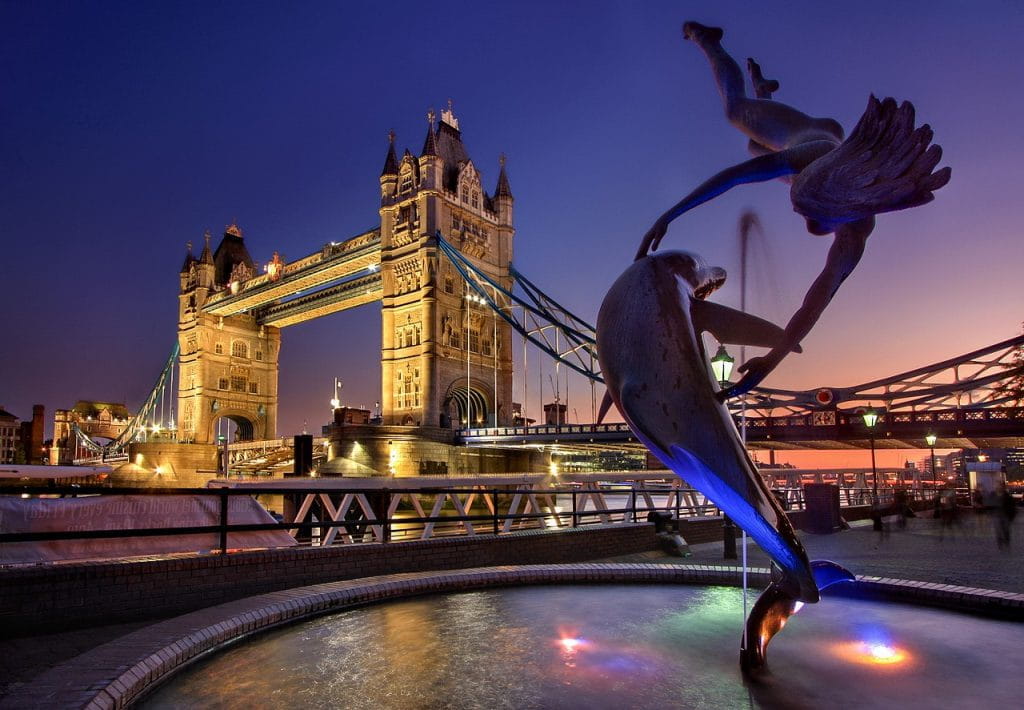 Erleuchtete Tower-Bridge mit einem Monument im Vordergrund.