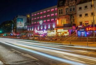 Bunt ausgeleuchtete Spielhalle und andere Geschäfte auf Hamburgs Reeperbahn bei Nacht.