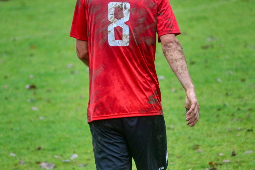 Rücken eines verdreckten Fußballspielers im roten Trikot mit der Nummer acht.