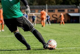 Torhüter schießt einen Ball während einer Fußballpartie.